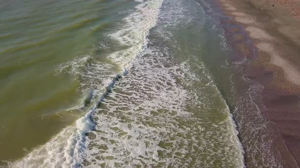 Drone view of the beautiful waves on the sandy beach,