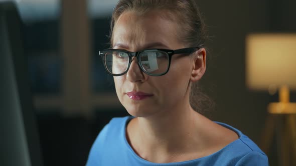 Woman in Glasses Looking on the Monitor and Surfing Internet