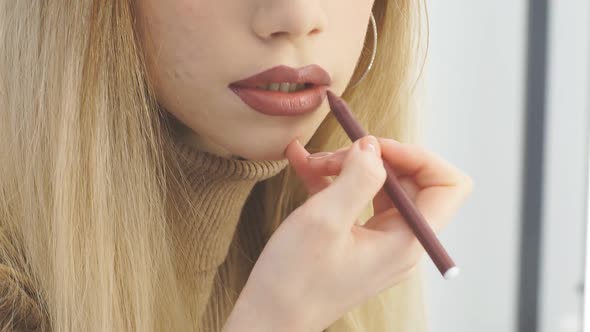 Closeup View of a Professional Makeup Artist Applying Lipstick on Lips