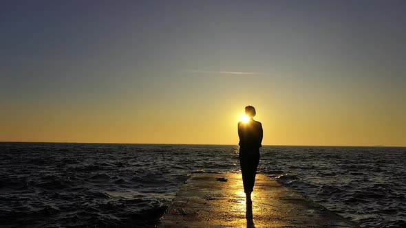 Slow motion female walking and ocean sunset with waves