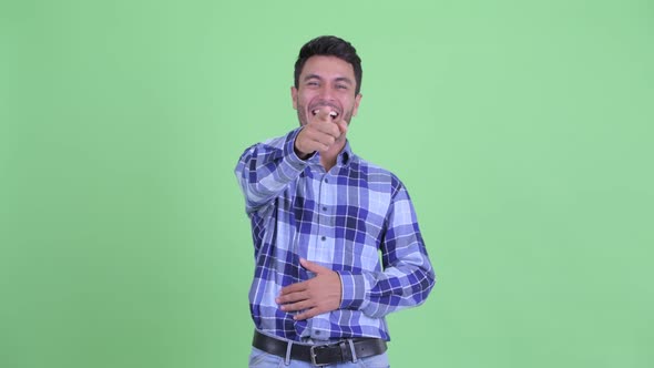 Happy Young Hispanic Man Laughing and Pointing at Camera