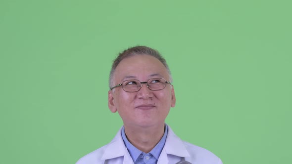 Face of Happy Mature Japanese Man Doctor Thinking