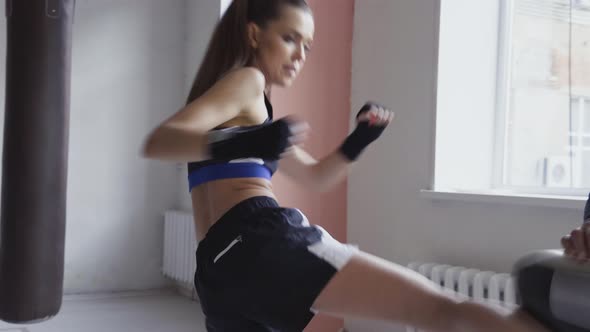 Female Martial Arts Fighter Practicing with Trainer Punching Taekwondo Kick Pad Exercise Kicking