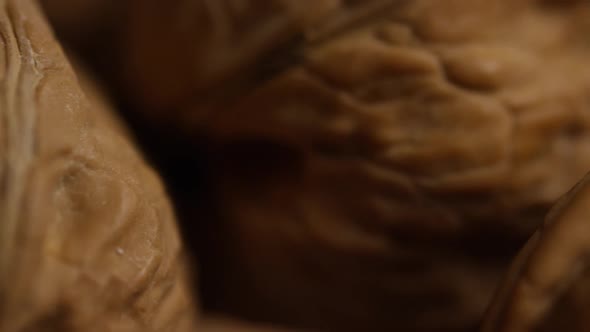 Cinematic, rotating shot of walnuts in their shells on a white surface - WALNUTS 