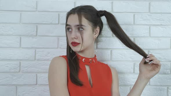 Young girl with red lips and tails on her head.