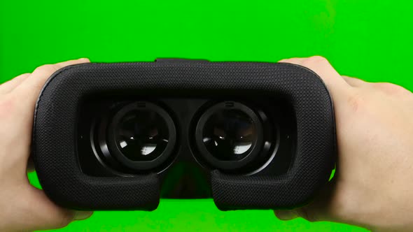 Male Hand Taking a Virtual Reality Headset. Virtual Reality Mask. Green Screen. Close Up
