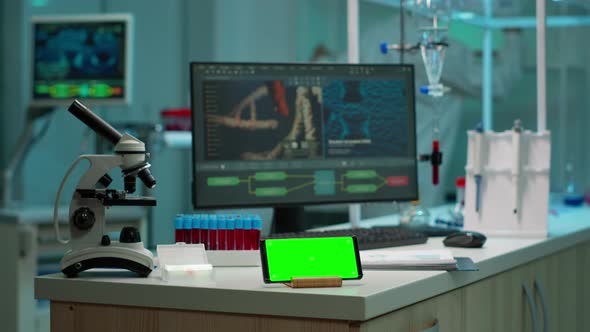 Scientist Using Smartphone with Green Screen Placed on Desk