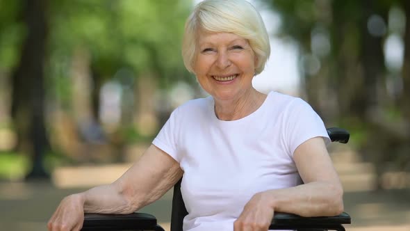 Smiling Woman in Wheelchair Enjoying Fresh Air, Comfortable Equipment, Close-Up