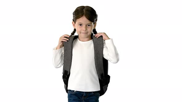 Smiling Little Girl Walking To School Holding Her Backpack and Looking at Camera on White Background