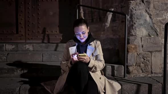 Young Woman Using Smartphone on Night City Street