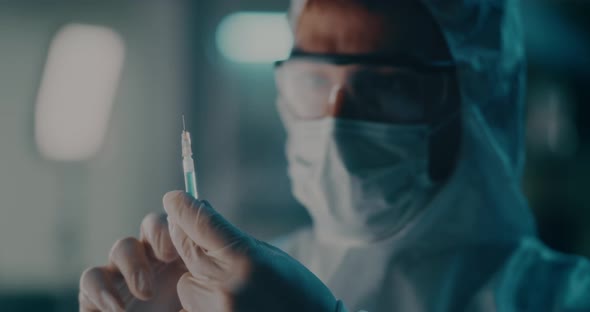 Doctor in Protective Suit Preparing Vaccine Injection