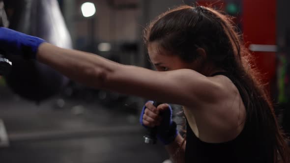 Female Boxer Strikes Using Dumbbells at Boxing Gym