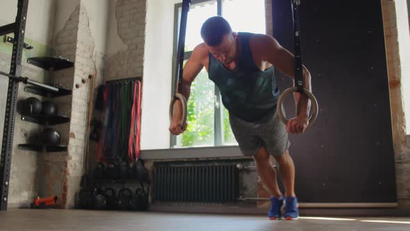 Man Doing Push-ups on Gymnastic Rings in Gym