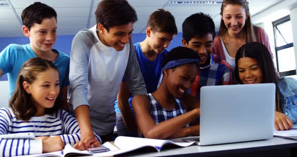 Group of students using laptop in classroom