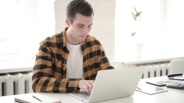 Ill Young Man Coughing While Using Laptop