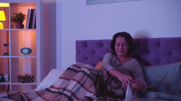 Senior Woman in Bed Crying While Watching Drama on Tv at Home