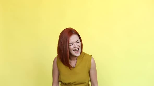 Emotional Girl with Red Hair Shouting Over Yellow Background.