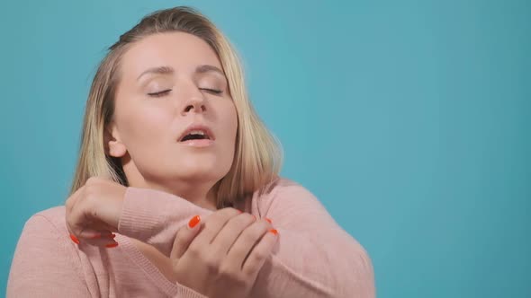 Lady with Long Loose Fair Hair Sneezes Into Upper Sleeve