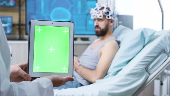 Doctor in a Neurology Clinic Holding Tablet with Green Screen