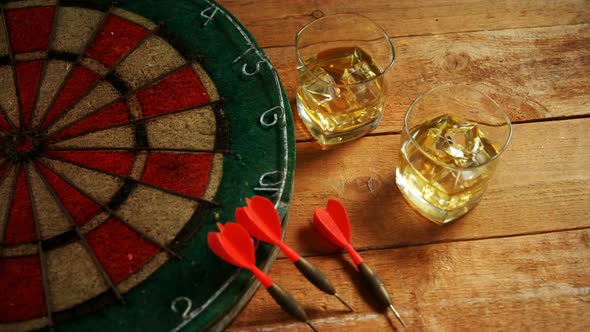 Dart and whisky on wooden table 4k