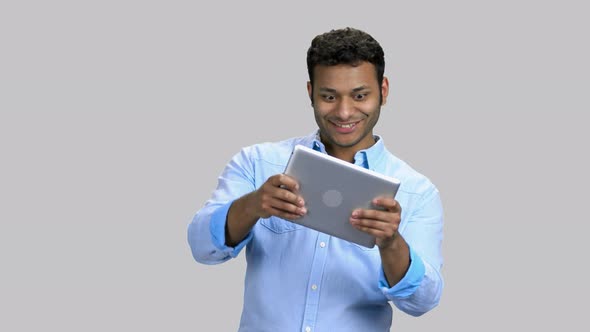 Young Darkskinned Man Playing Tablet Pc Game