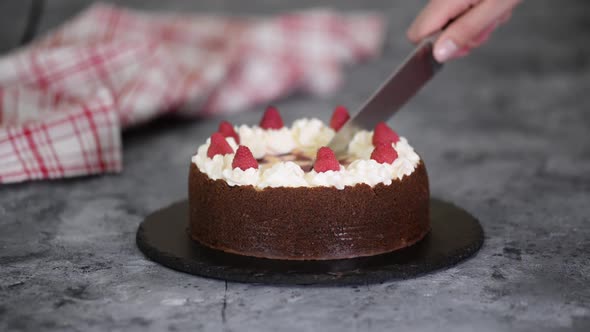 Cutting homemade raspberry chocolate cheesecake.