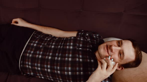 Young Smiling Man Using 3d Massager for Face