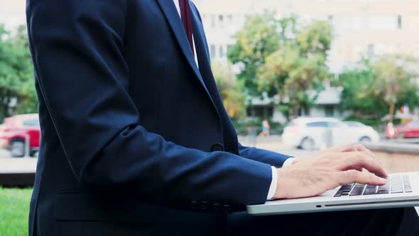 Businessman Hands Typing on Laptop Keyboard Outdoor in the City, Close Up Static