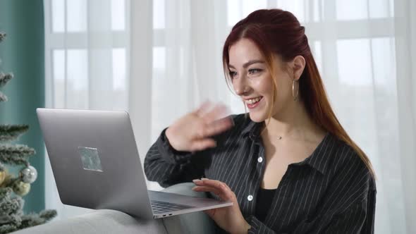 Portrait of Cheerful Young Woman Waving and Talking at Selfie Camera on Laptop. Happy Smiling