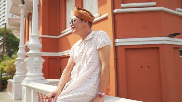 4K Confidence Asian lgbtq guy wearing woman clothes with sunglasses walking down city street.