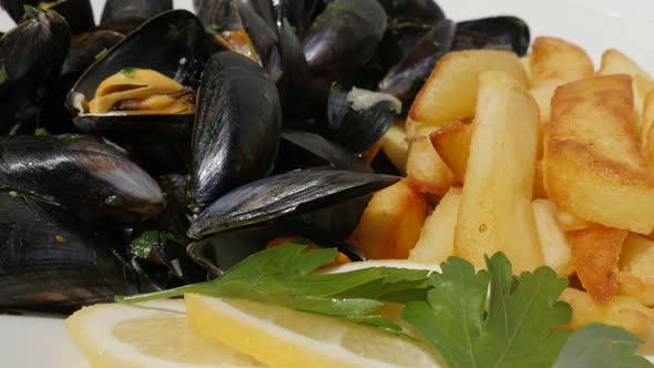 Lot of blue common mussels with french chips  fries and lemon 4K 2160p 30fps UltraHD footage - Slice