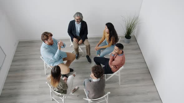 Troubled Man Sharing Problems with People Discussing Emotions at Group Therapy