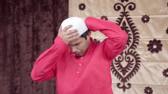 Muslim man adjusting his cap