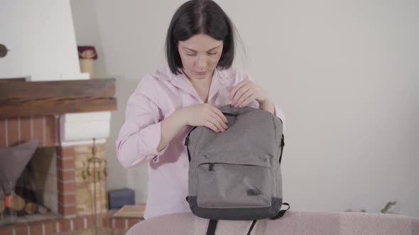 Portrait of Worried Caucasian Brunette Woman with Brown Eyes Finding Condom in Child's Backpack