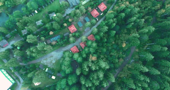 Top-down View Of Mountain Cabin With Lush Green Coniferous Forest