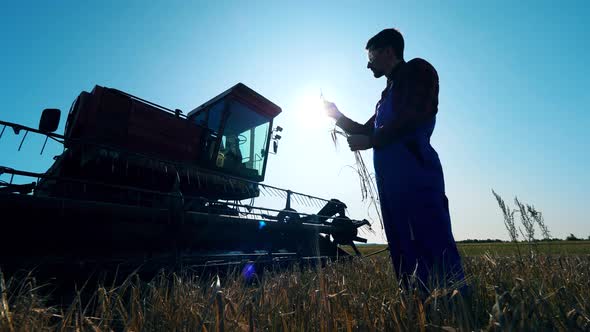 Male Cultivator, Farmer Is Standing in the Field Next To the Harvester