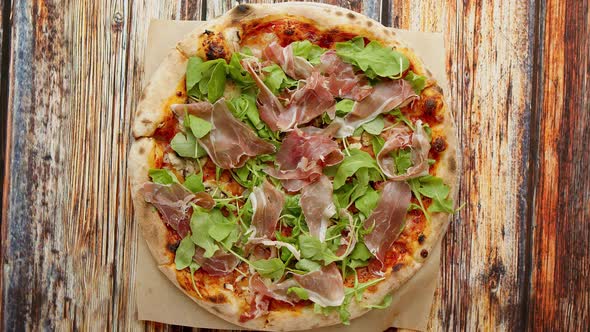 Delicious Homemade Italian Prosciutto and Rucola Pizza Placed on Wooden Background