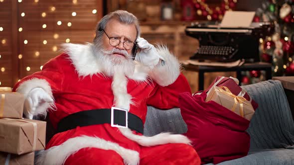 Shocked Male Santa Claus Having Bad News Talking Smartphone at Festive Home