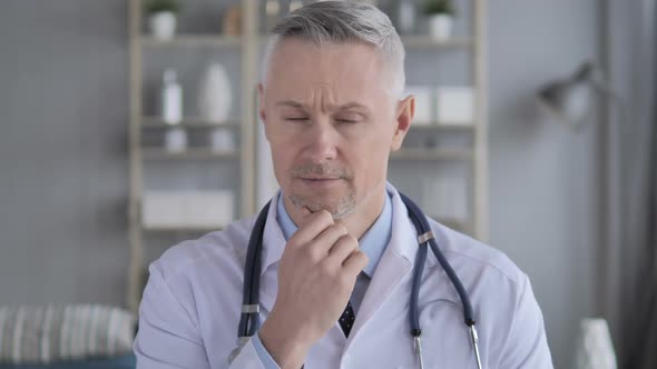 Portrait of Thinking Pensive Doctor with Grey Hairs