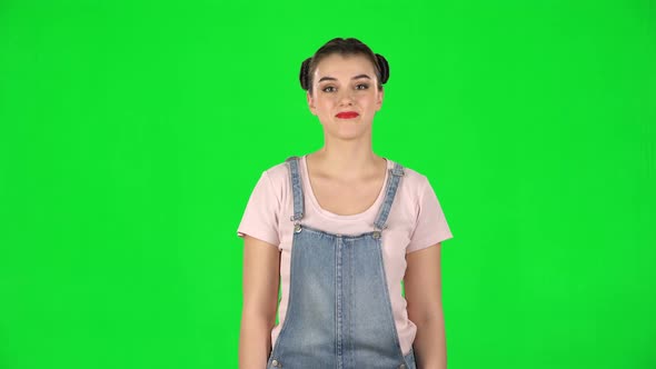 Cunning Girl Looking at Camera, Smiling with Tight Red Lips on Green Screen