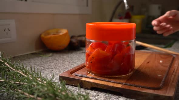 Hand Takes Jar With Prepared Bell Pepper In Sunflower Oil. close up, slow motion