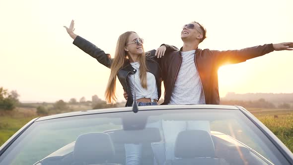 Stylish Young Couple Enjoying Beautiful Landscape During Rest After Trip in the Cabriolet