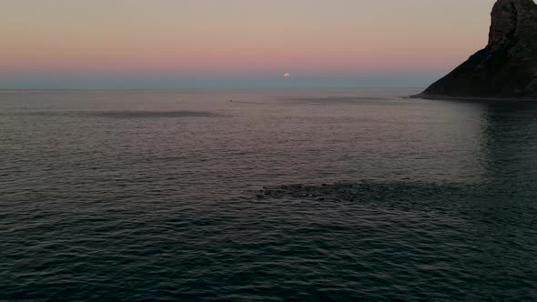 Aerial view of Blood Moon lunar eclipse and dolphins swimming Hout Bay.