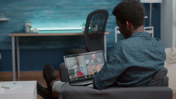 African American Man Unsing Laptop for Online Internet Conference Chat with His Coworkers