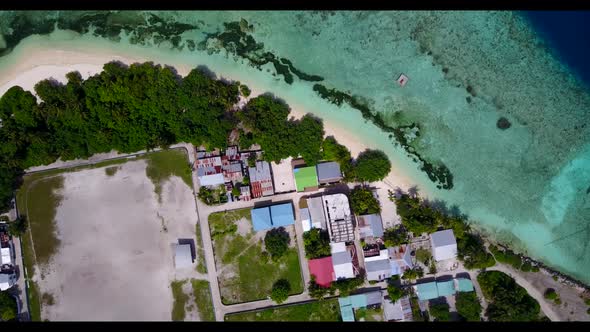 Aerial drone seascape of tropical seashore beach vacation by blue lagoon with white sandy background