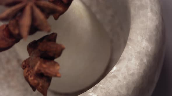 Granite Mortar and Star Anise Spice Species Falling in Slow Motion