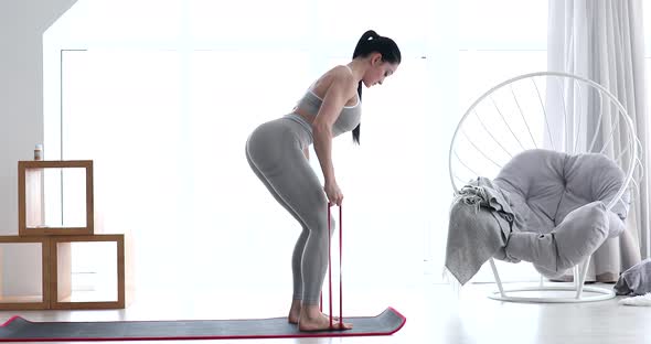 Woman doing exercises with resistance bands at home.