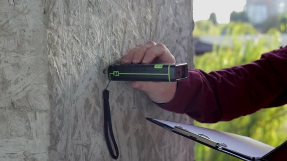 Building Engineer does Measurements of the Building