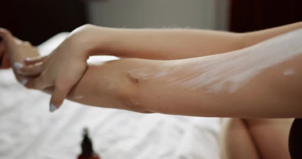 A woman is putting cream on her arm  4K