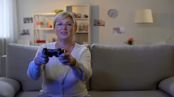 Happy Mature Lady Pressing Console Buttons Playing Video Game Sitting Home Sofa